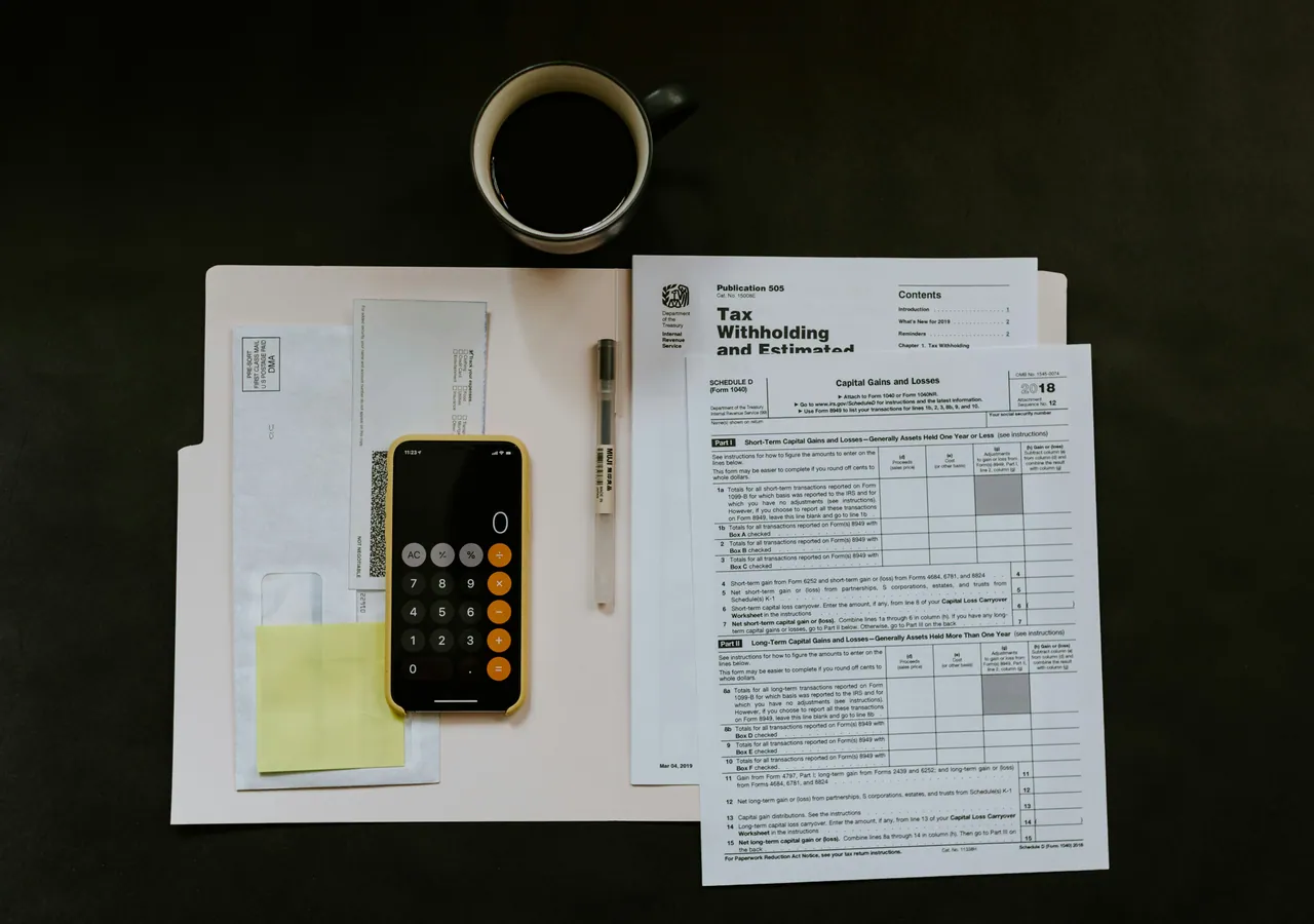 Tax forms and a calculator on a desk.